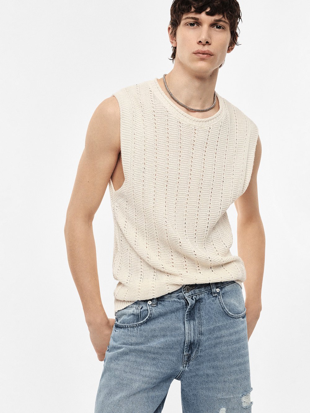 Three models wearing knitwear and denim: cream sleeveless knit, striped tee with wide-leg jeans, black cardigan over tee