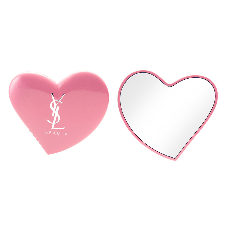 Uno specchietto da borsa rosa a forma di cuore YSL Beaut&eacute;, mostrato chiuso con il logo bianco e aperto dal lato dello specchio.