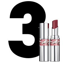 Un grande numero "3" nero accanto a un rossetto d'argento YSL Loveshine, mostrato sia chiuso che aperto in una tonalit&agrave; legno di rosa.