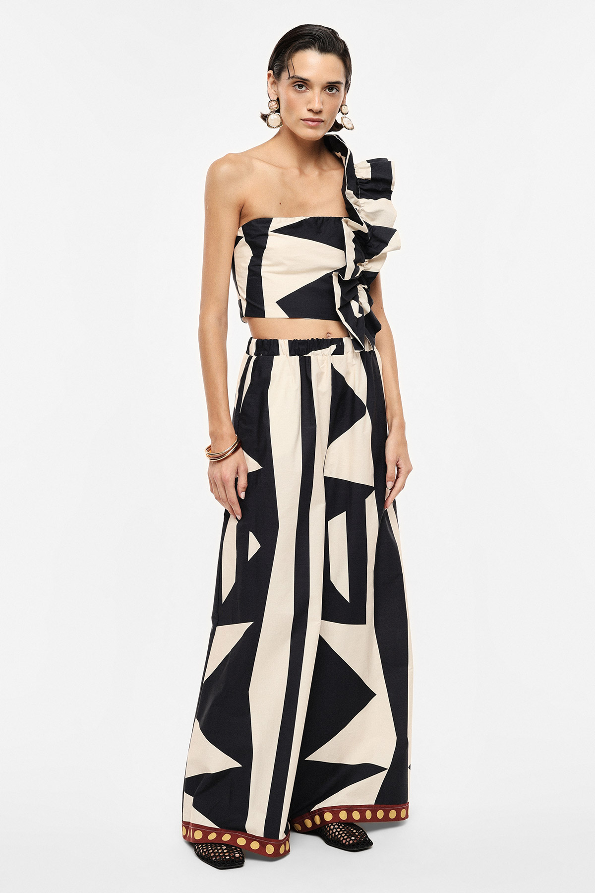 Woman modelling black-and-cream geometric one-shoulder ruffle crop top with matching wide-leg trousers