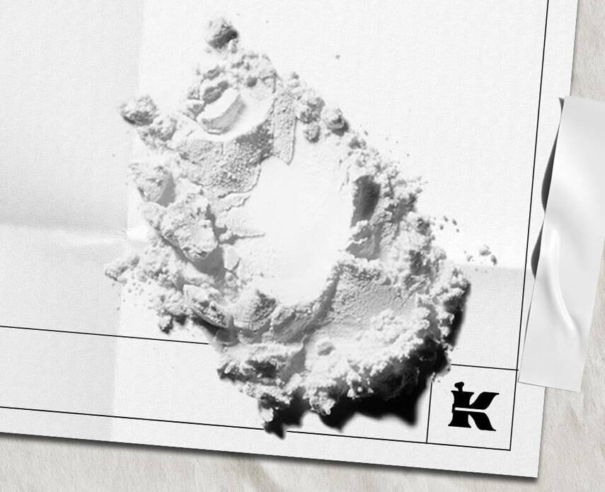 Cumulo di polvere e grumi di argilla bianca con logo Kiehl's in basso a destra su foglio bianconsioni