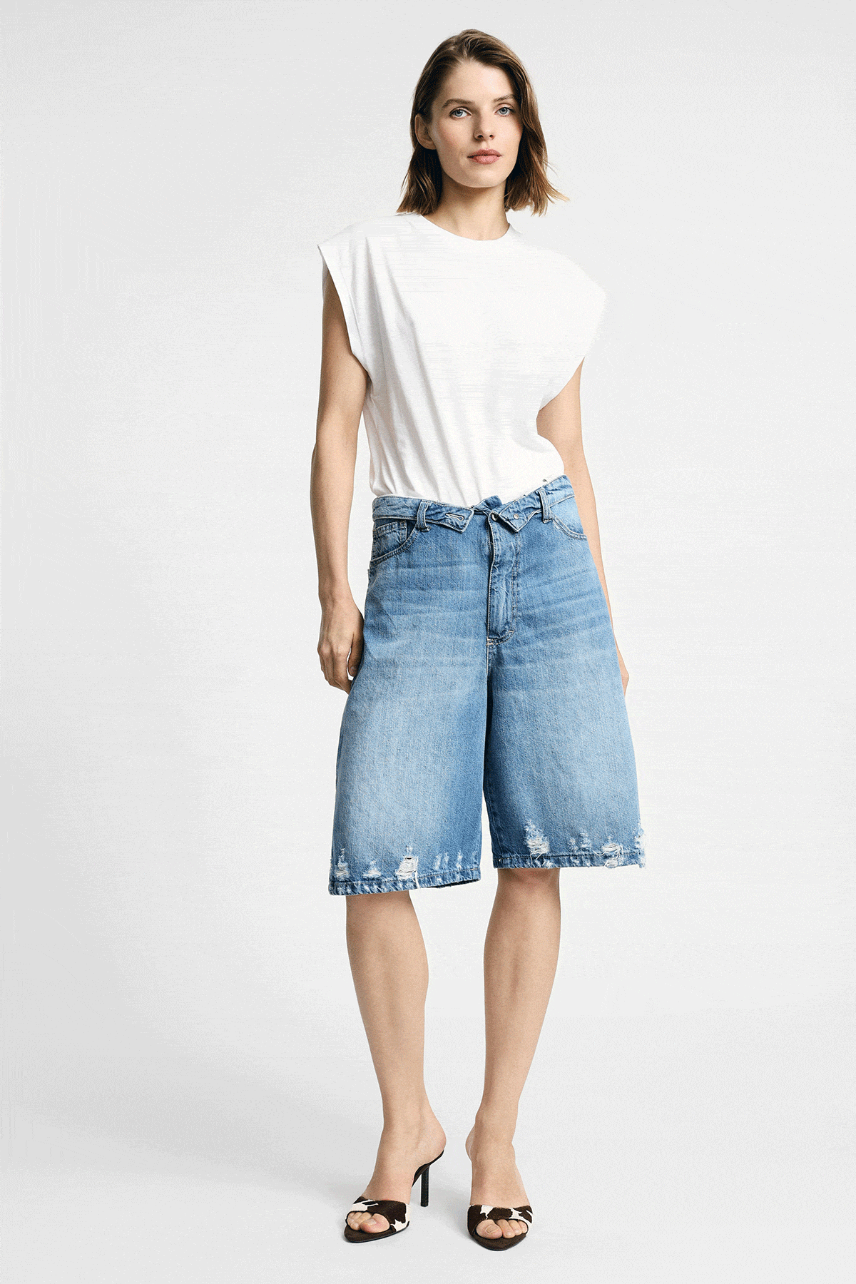 Collage of female models showcasing women's denim: long shorts, wide-leg jeans back view, ruffled denim cami top and beige jacket outfit