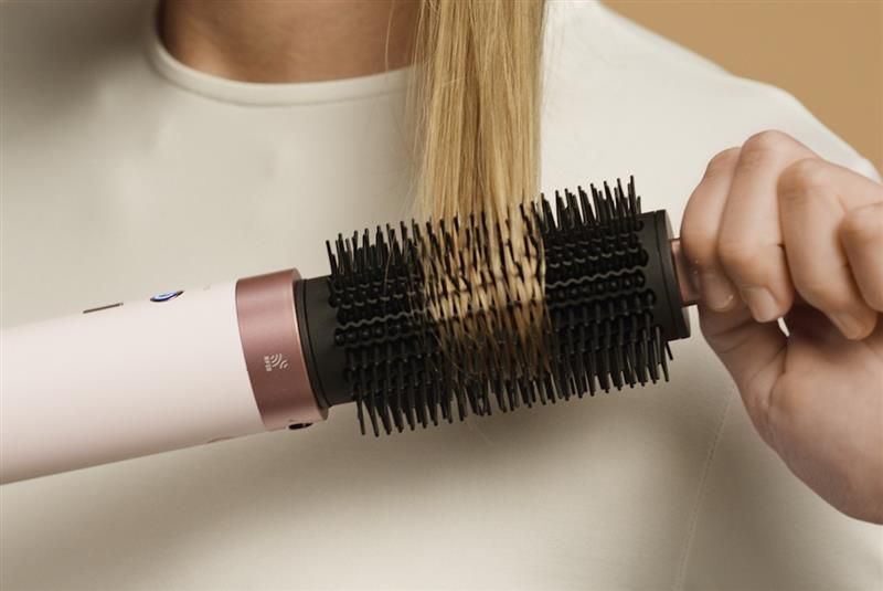 Hair is brushed with the Dyson Airwrap Co-anda2x Round volumising brush 2x.