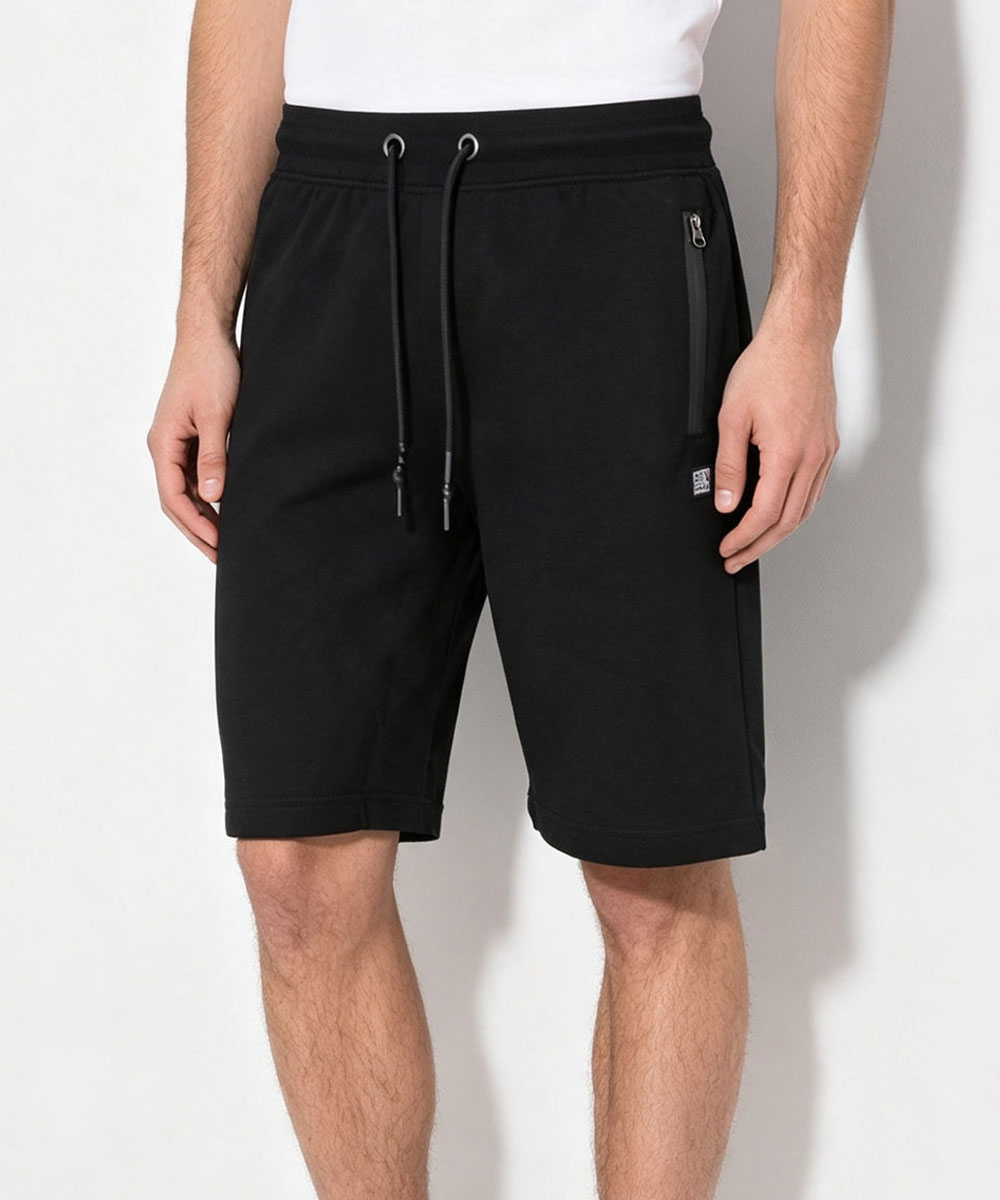 Black men's knee-length drawstring shorts with zip side pocket, relaxed fit cotton blend worn by model against plain white background