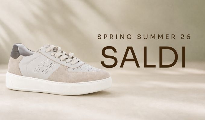 Beige and white low-top suede sneaker with perforated side detail on neutral background, 'Spring Summer 26 SALDI' sale graphic