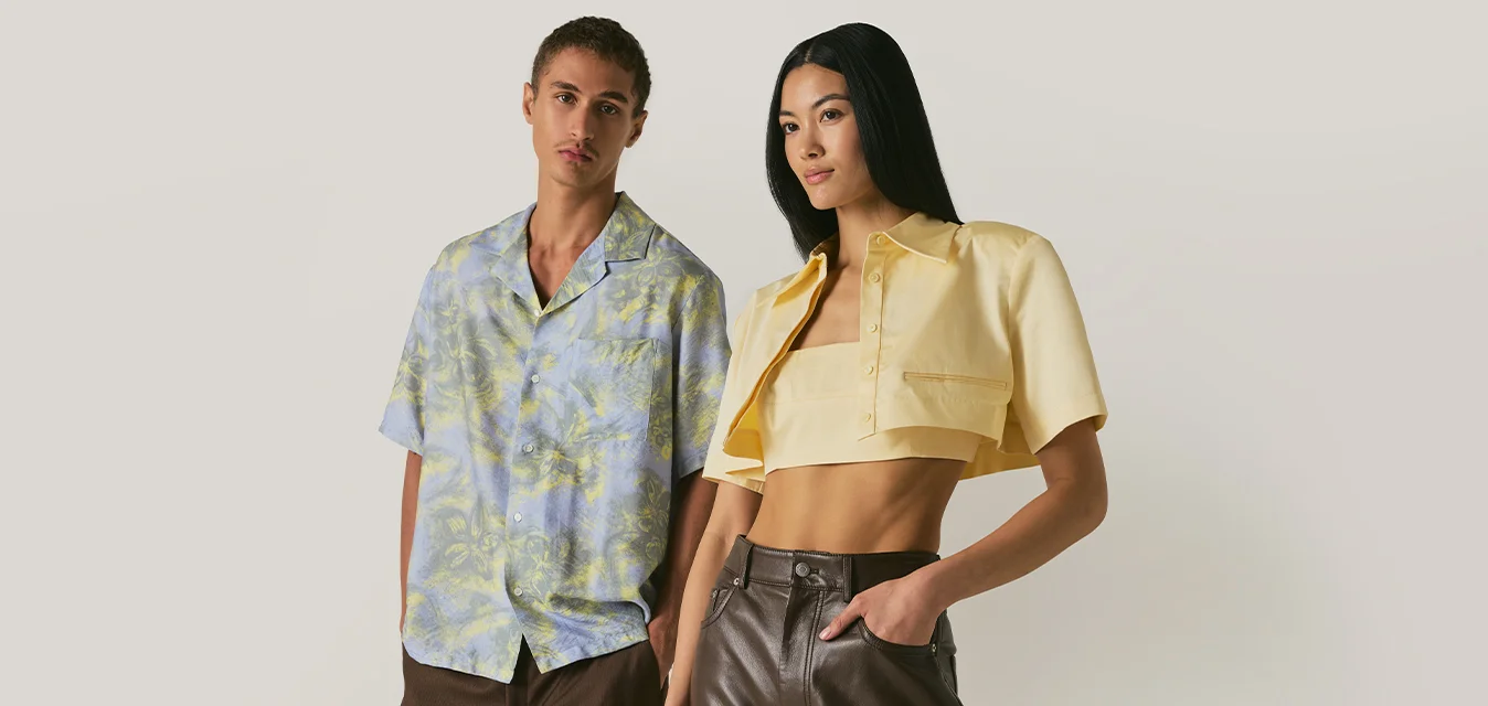 Giovane uomo e donna in piedi fianco a fianco, indossando abiti estivi casual e alla moda su uno sfondo beige semplice.