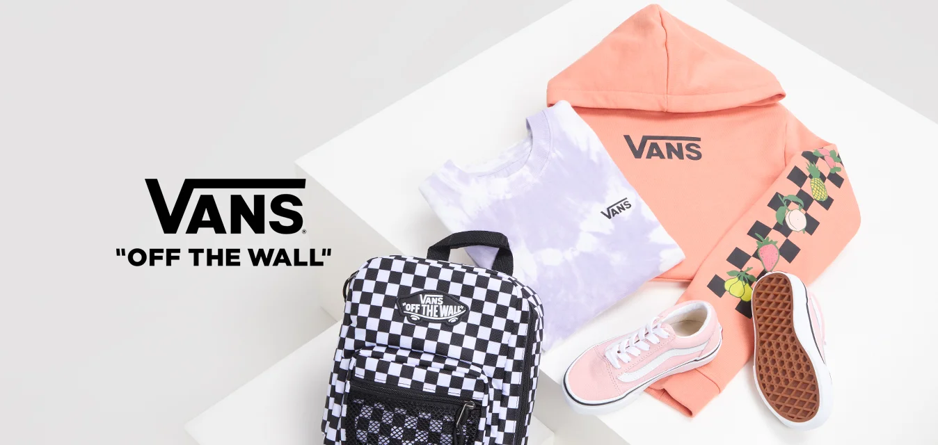 Felpa rosa Vans, maglietta tie-dye, zaino a scacchi e sneaker rosa con suole bianche, caratterizzati da accenti di frutta e materiali testurizzati.
