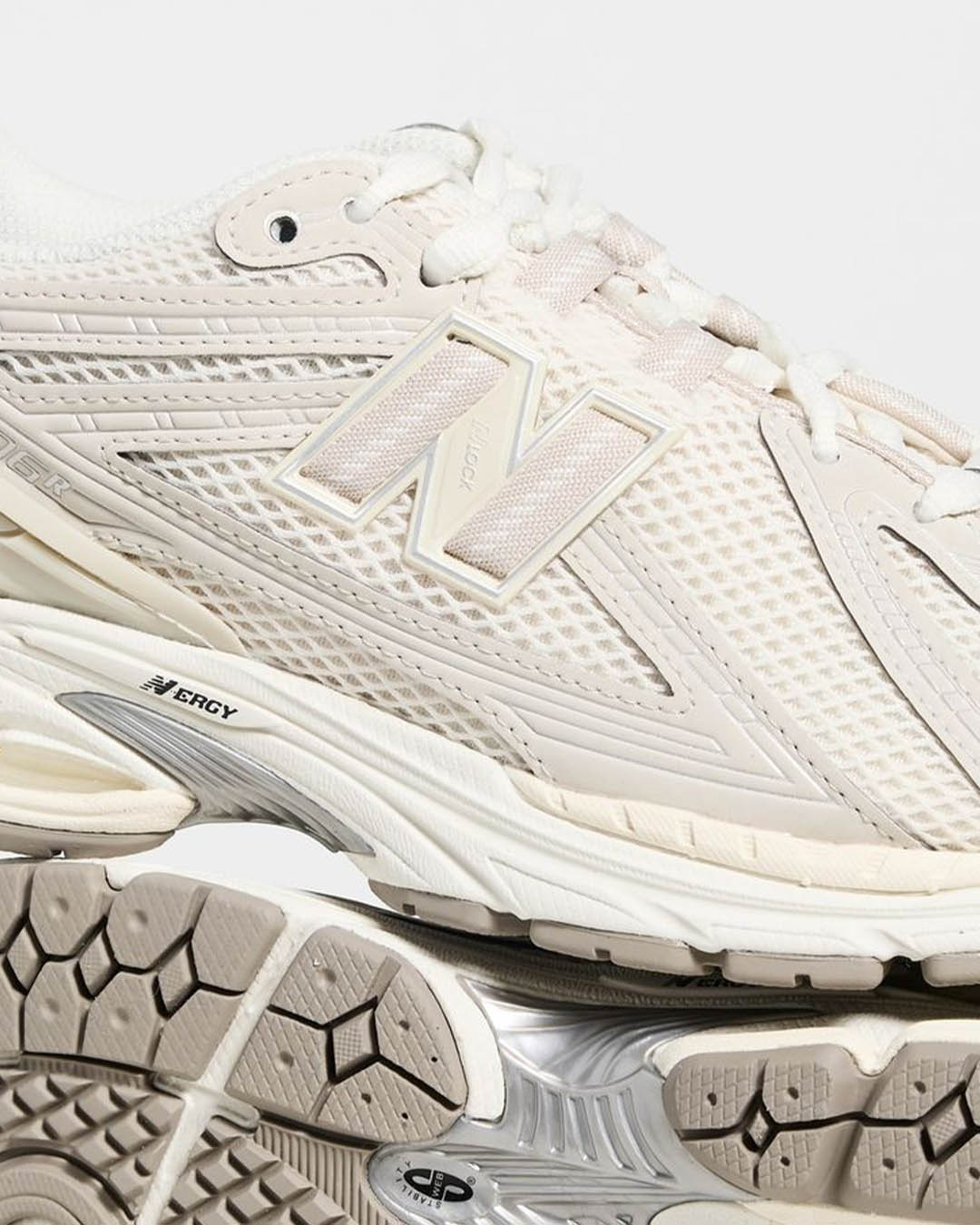 Close-up of beige New Balance running shoe showing mesh upper, N logo, cushioned midsole and textured rubber outsole