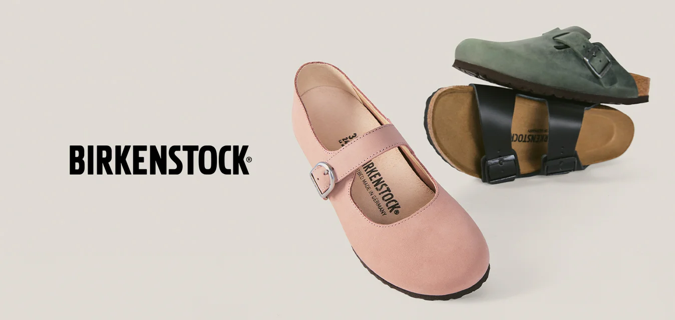 Scarpa Mary Jane rosa con fibbia e due sandali Birkenstock verdi e neri con cinturini con fibbia su sfondo beige.