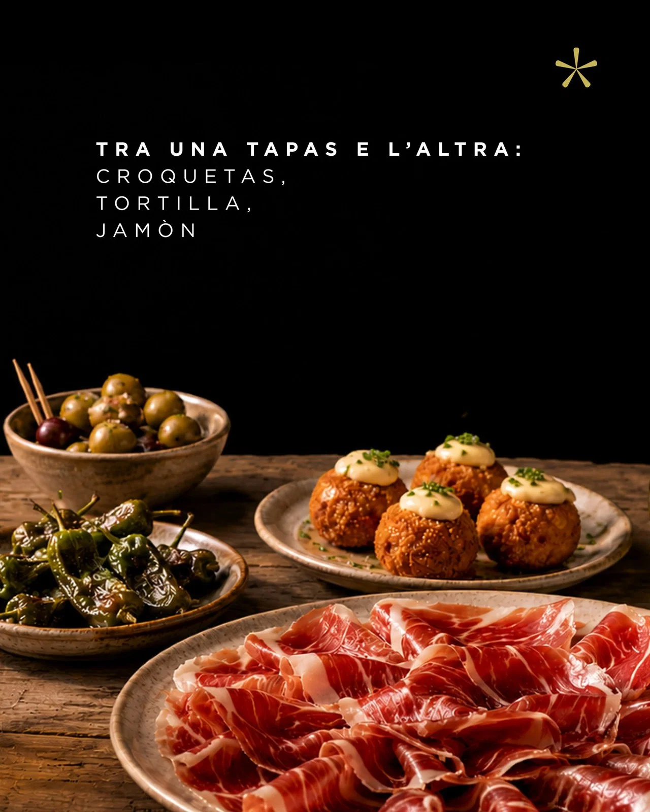 Tavola di tapas spagnole con croquetas, peperoni di Padrón, olive e jamón, da abbinare al Niro 75