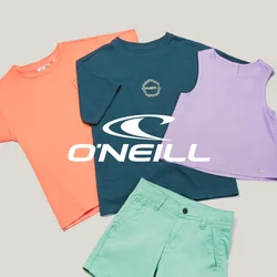 Tre t-shirt colorate, pantaloncini verdi e un pallone da calcio blu disposti su uno sfondo chiaro e uniforme.
