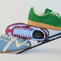 Tre sneaker colorate in blu, rosso e verde bilanciano su una barra metallica nera inclinata su uno sfondo chiaro.