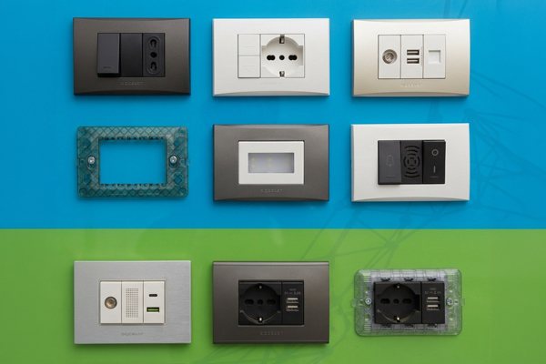 Array of modern electrical wall sockets, USB ports and switch plates displayed on blue and green background