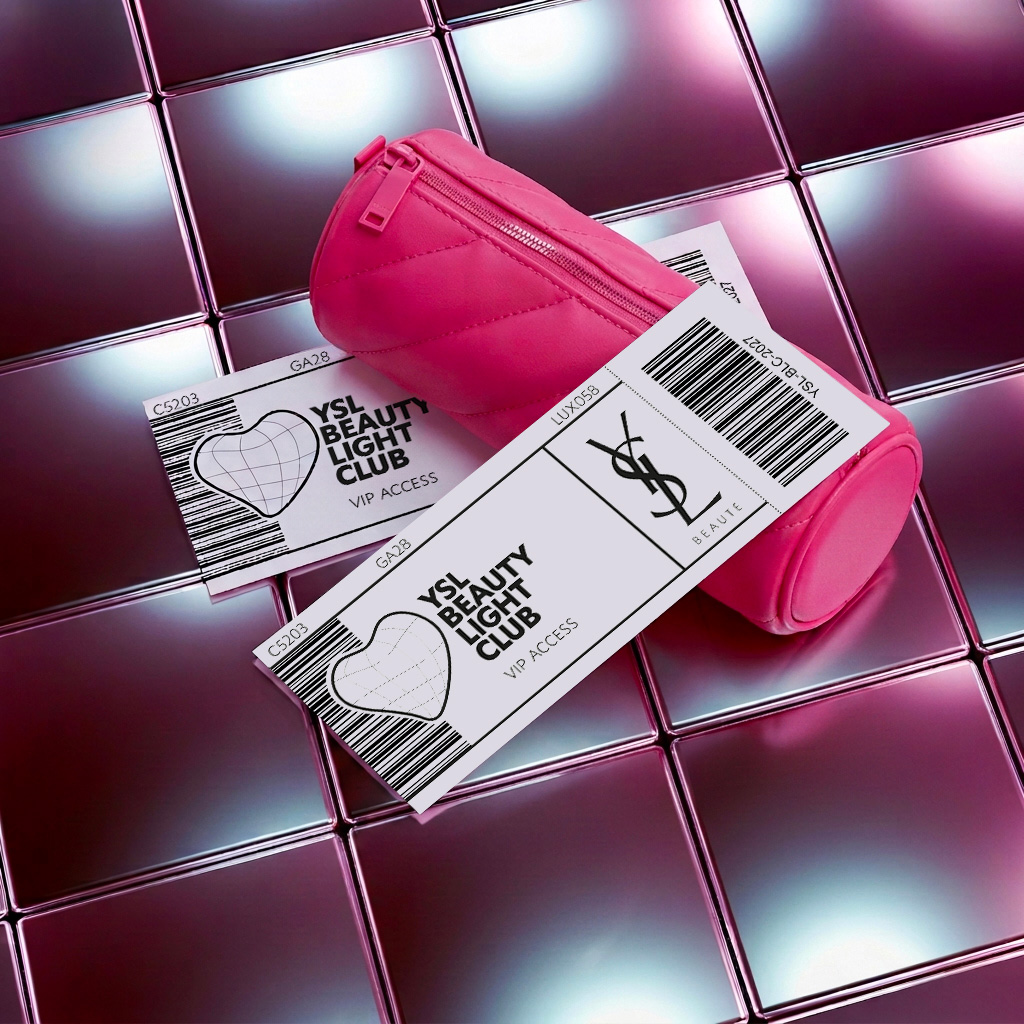 Una trousse trapuntata rosa brillante e due biglietti d'accesso VIP per il YSL Beauty Light Club disposti su piastrelle metalliche riflettenti.
