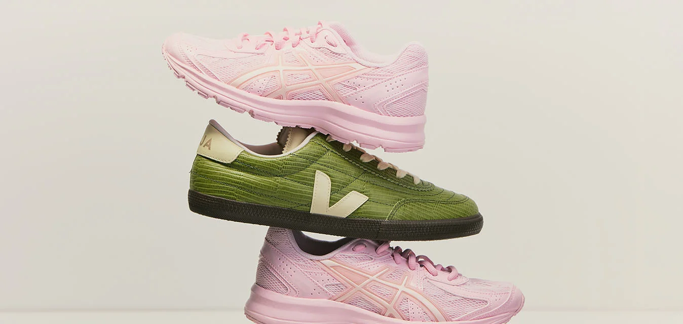 Due sneakers rosa e due sneakers verdi con loghi bianchi sono impilate alternativamente in una disposizione verticale equilibrata su uno sfondo semplice.