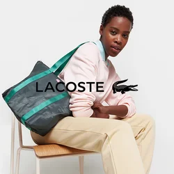 Borsa a tracolla realizzata in materiale nero testurizzato con manici verdi, caratterizzata da un motivo geometrico e un logo rosa. Tracolla regolabile per versatilità.