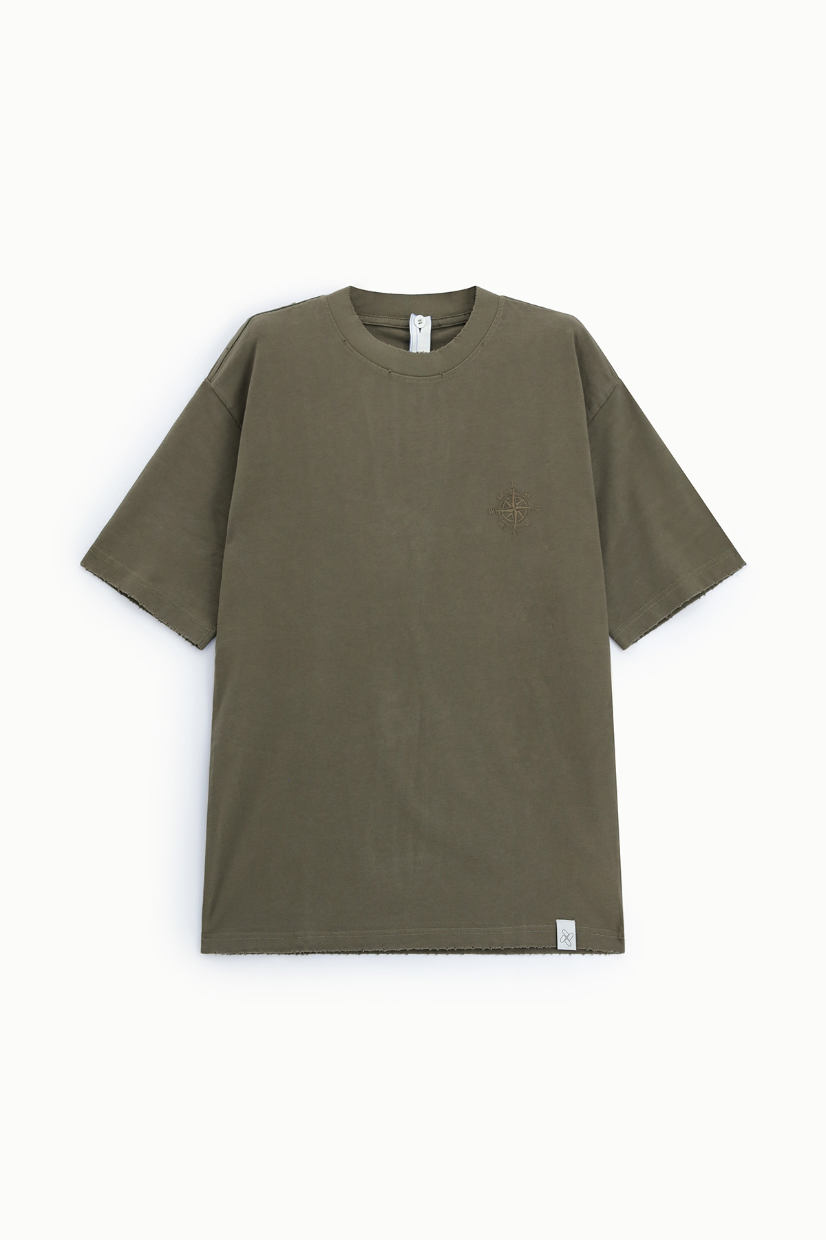Olive green oversized short-sleeve cotton T-shirt with small compass embroidery on left chest and woven brand label at hem, flat lay
