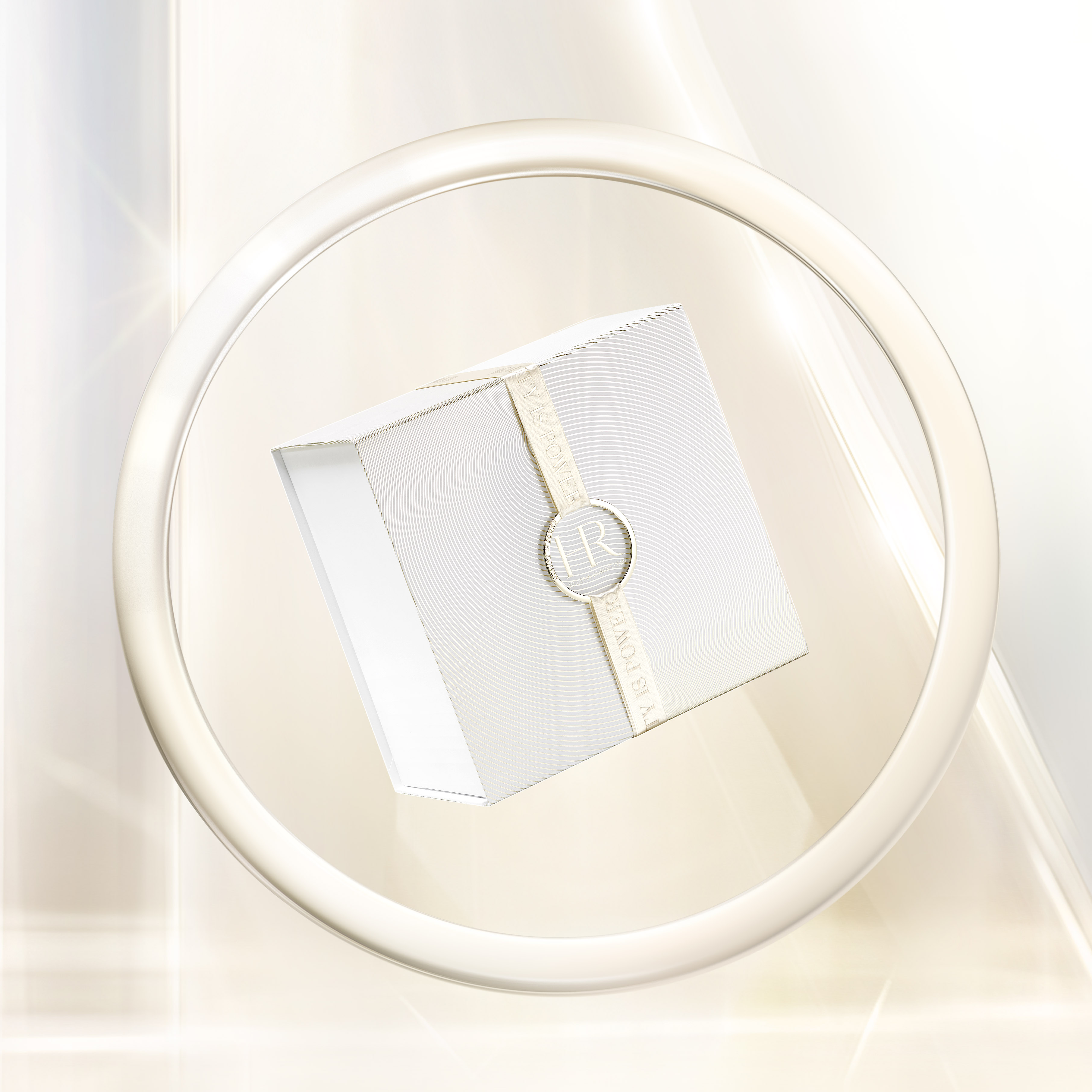 Lussuoso cofanetto regalo Helena Rubinstein, dal design bianco testurizzato e minimalista, circondato da un delicato nastro con le iniziali del marchio, allestito in un cerchio luminoso ed elegante.