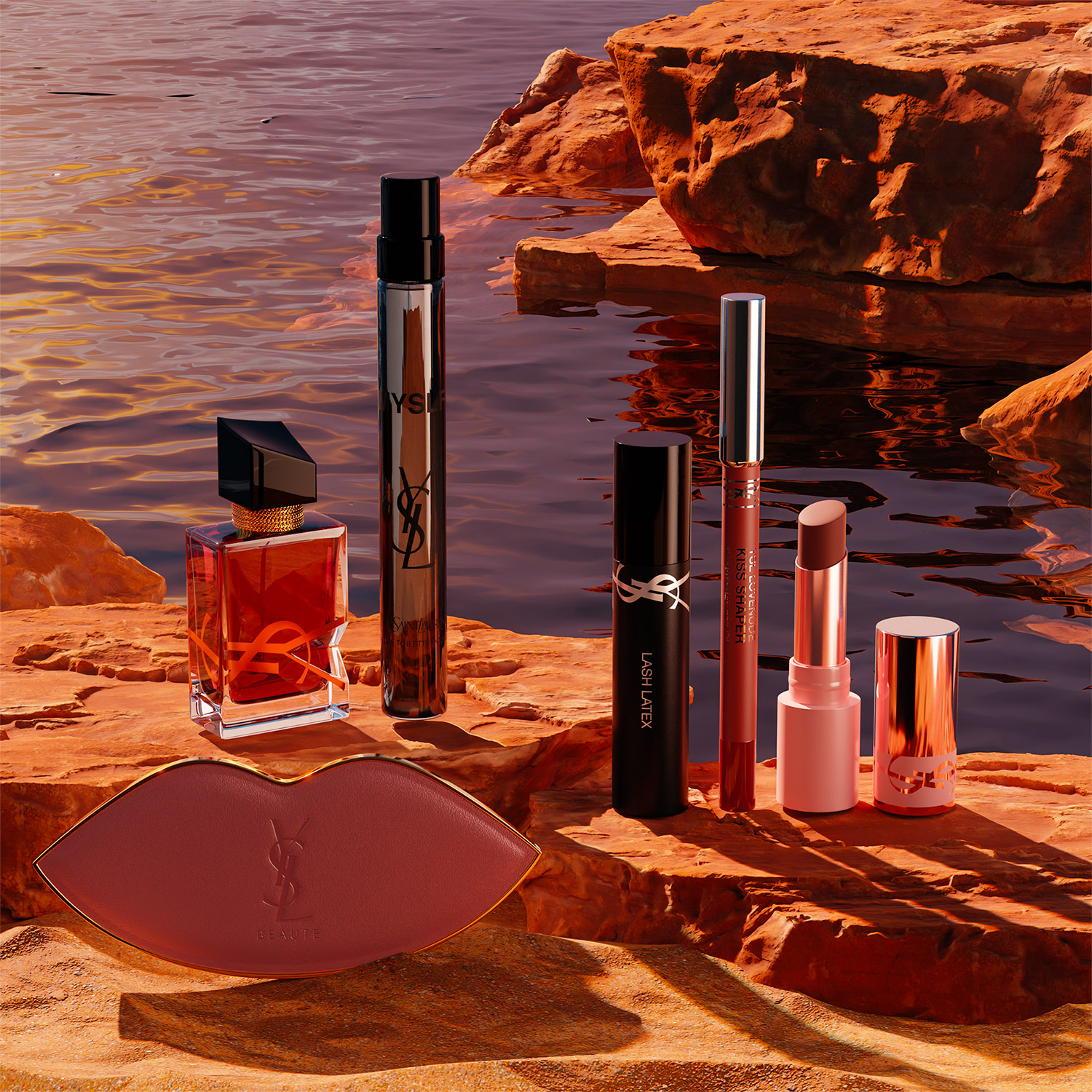 Una selezione di prodotti di bellezza YSL, tra cui profumo, mascara, rossetto e una cipria a forma di labbra, disposti su rocce rosse in riva all'acqua.