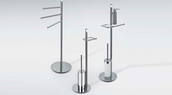 Set of modern chrome freestanding bathroom accessories including towel stand, toilet brush and toilet roll holder on white background