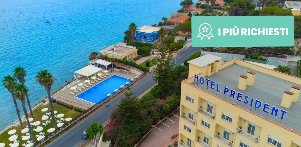 Aerial view of Hotel President by the Mediterranean: beachfront pool, rows of sun loungers, palm trees and turquoise sea.