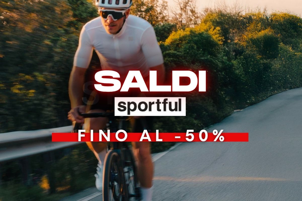 Cyclist on a winding road at sunset with text 'SALDI Sportful FINO AL -50%' promoting road cycling kit sale up to 50% off