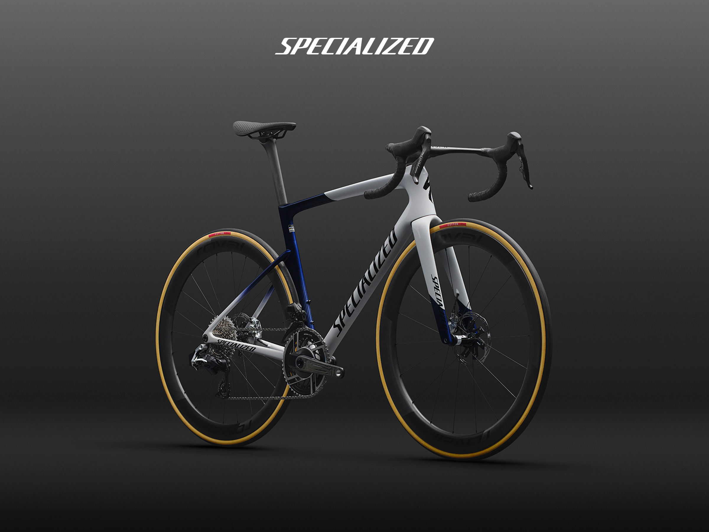 Specialized road bike in white and navy with tan-wall tyres, aerodynamic carbon frame and disc brakes on dark background