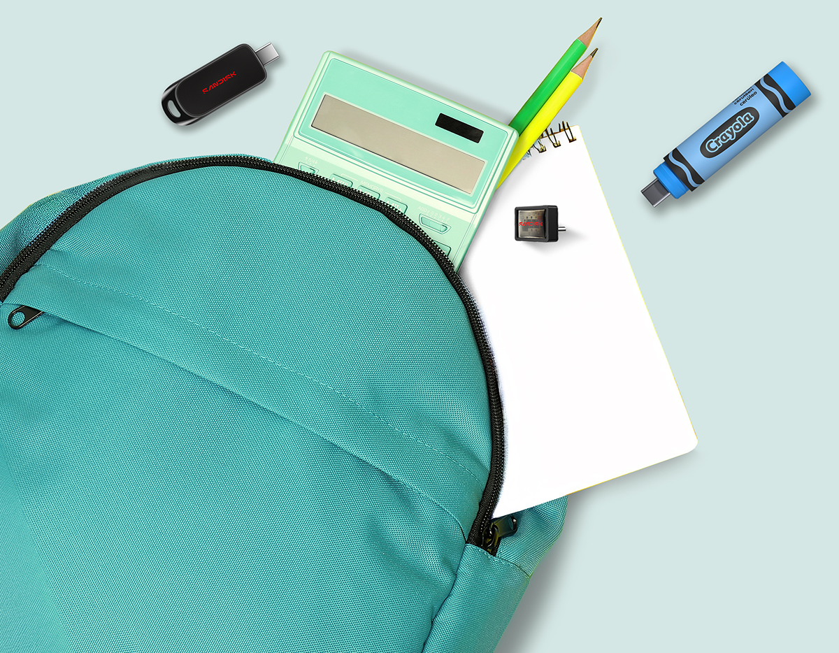 Primo piano di uno zaino turchese con calcolatrice, taccuino, matite e unit&agrave; USB Sandisk, tra cui un'unit&agrave; flash USB-C SANDISK nera, un'unit&agrave; flash USB-C SANDISK Extreme Fit e un'unit&agrave; flash USB-C SANDISK Crayola blu ceruleo.