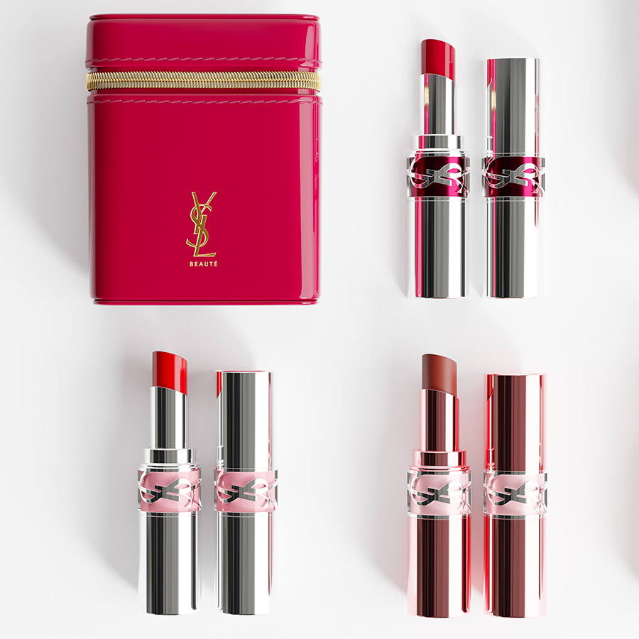 Un beauty case YSL rosa fucsia circondato da tre rossetti YSL Loveshine in astucci argento e oro rosa.