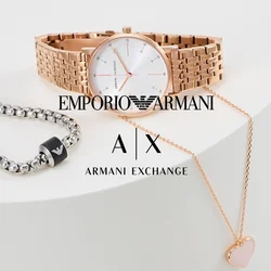 Orologio in oro rosa con cinturino a rete e quadrante bianco, bracciale in argento con accento nero, e collana con pendente a forma di cuore in oro rosa.
