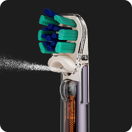 Lo spazzolino Dyson CameraJet spruzza un getto di collutorio.