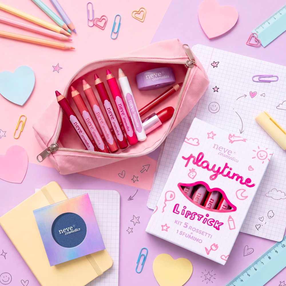 Pink pencil case open with assorted pink and red lip pencils, lipstick and Neve Cosmetics 'Playtime' lipstick set on a pastel stationery background