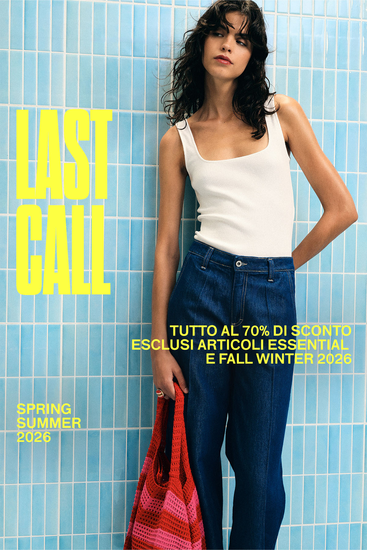 Young woman in white tank and high‑waist jeans holding red‑pink tote against blue tiled wall with 'LAST CALL' sale text