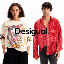 Due modelli, uno che indossa un maglione crema con una grafica colorata di Topolino, l'altro in una camicia rossa a fantasia con bottoni.