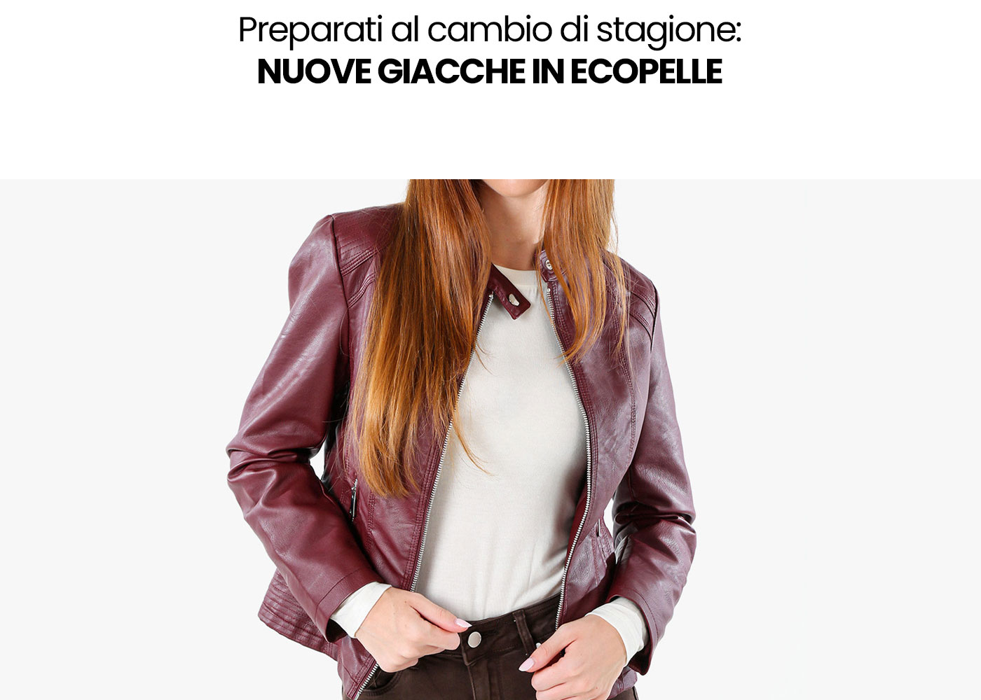 Woman wearing burgundy faux-leather jacket over cream top, hands at waistband, seasonal autumn style for new jackets