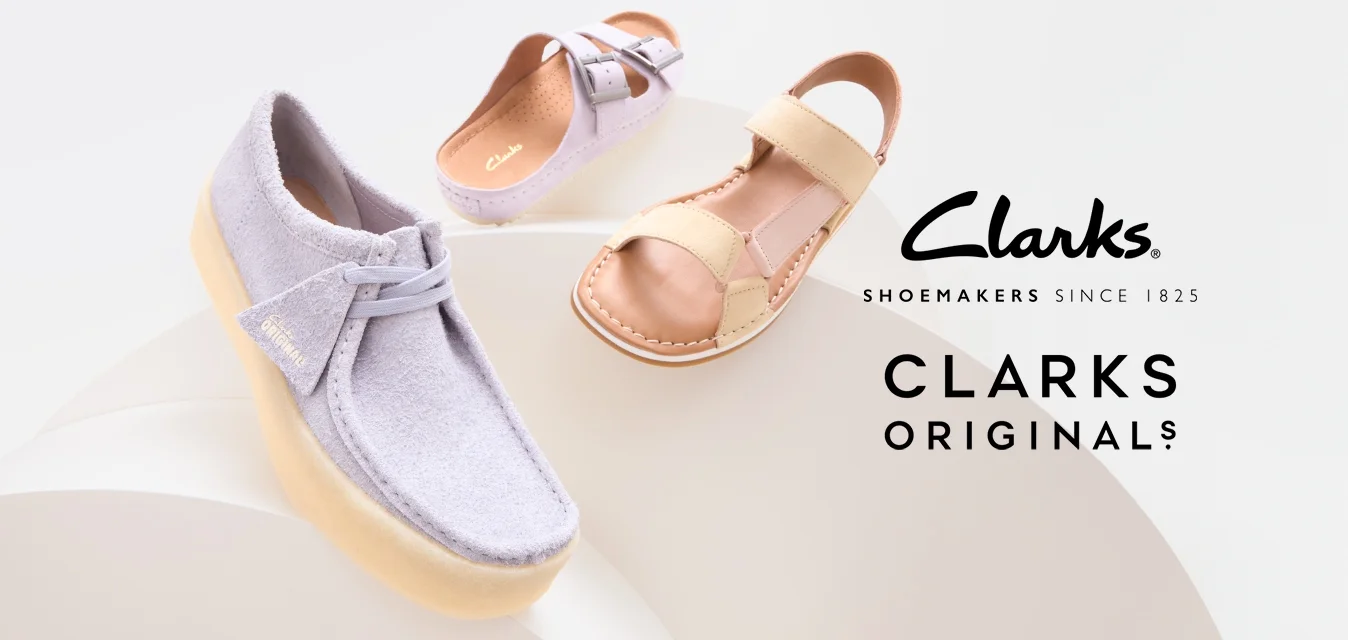 Tre paia di scarpe: una sneaker di suede lavanda con suola beige, un sandalo rosa chiaro con fibbia e un sandalo a cinturini crema su uno sfondo bianco.