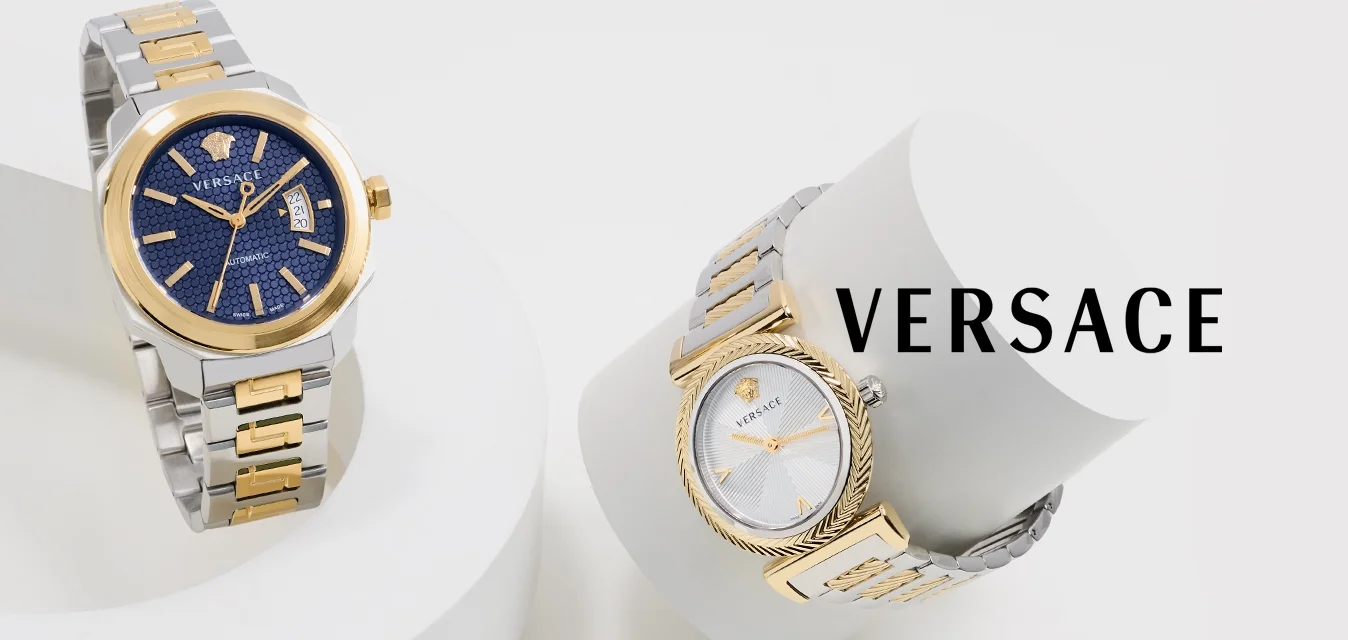 Due orologi da polso Versace con cinturini in metallo argento e oro su supporti geometrici bianchi, uno con quadrante blu, l'altro con quadrante bianco.