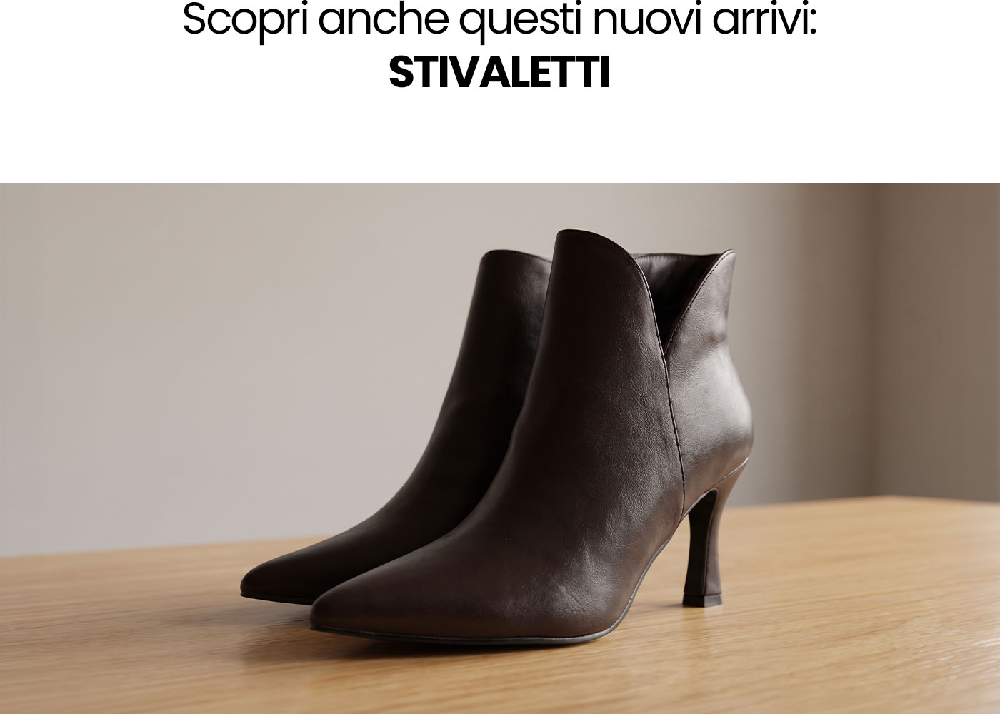 Dark brown leather ankle boots with pointed toes and slim mid heels displayed on a light wooden surface