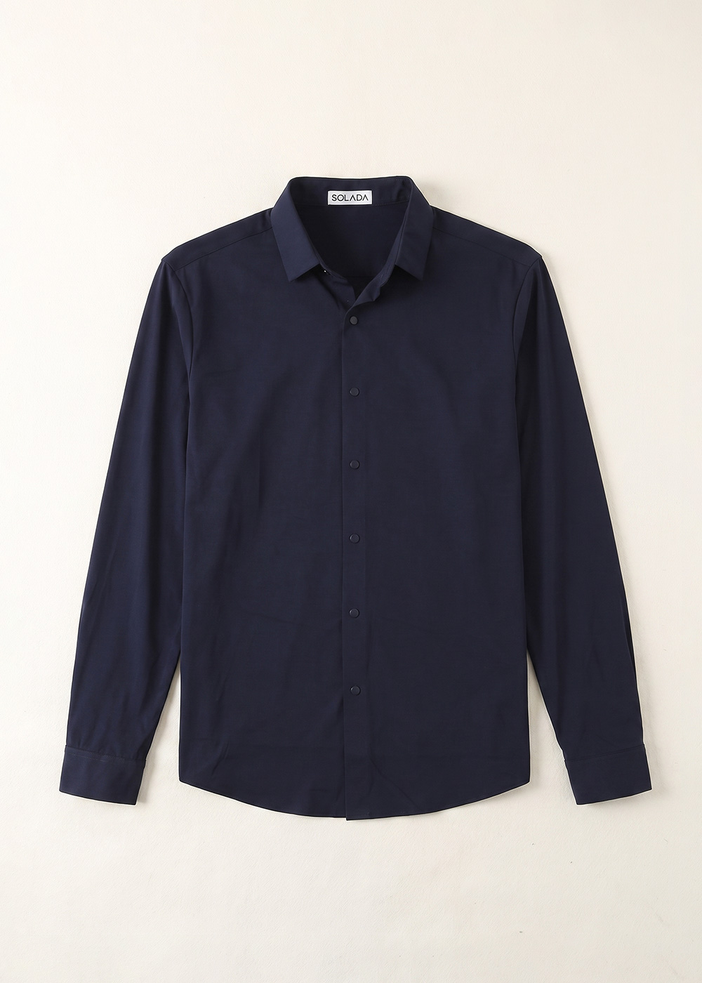 Men's navy long-sleeve button-front shirt with spread collar, slim fit, laid flat on cream background