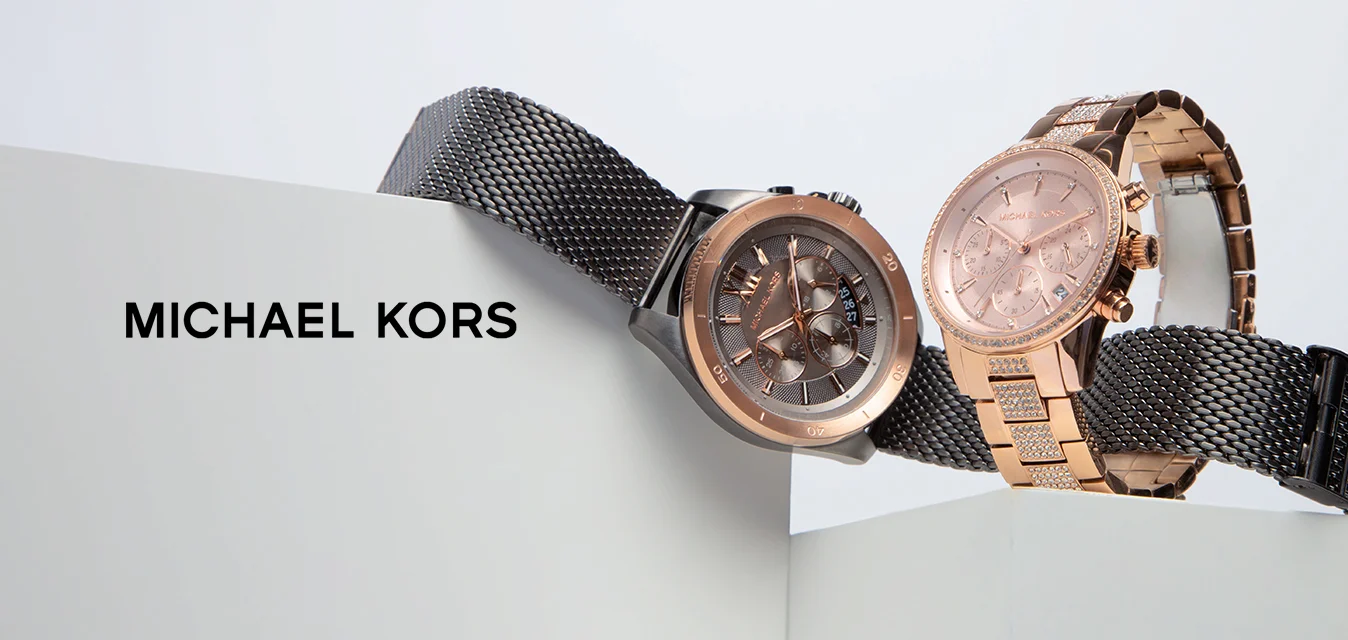 Due orologi esposti su una superficie bianca. Uno ha un bracciale in maglia scura con una cassa dal quadrante grigio; l'altro presenta un tono oro rosa con un bracciale a maglie.