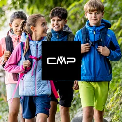 Quattro bambini con zaini che camminano su un sentiero nel bosco accanto a una recinzione di legno, circondati da alberi verdi e fogliame.
