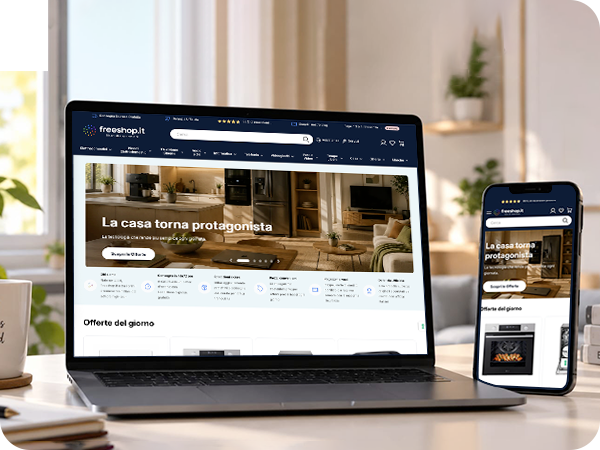 Laptop and smartphone on a desk showing Freeshop.it e-commerce homepage with a homeware banner reading 'La casa torna protagonista' and product listings