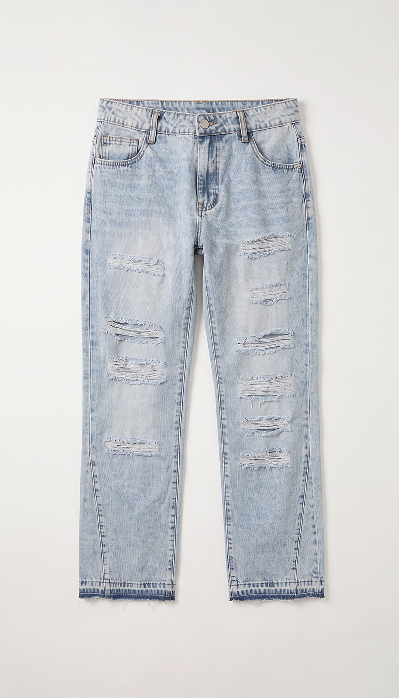 Light-wash distressed straight-leg denim jeans with multiple ripped panels and raw hem, laid flat on white background