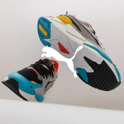 Sneakers atletici colorati che presentano una combinazione di materiali grigi, neri e bianchi, con accenti vivaci in rosso, arancione, giallo e blu.