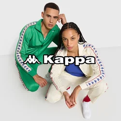 Due persone si accuattano su un pavimento bianco puro, indossando tute sportive coordinate: una verde e l'altra crema con un top blu e sneaker bianche.