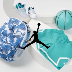 Zaino con motivo floreale blu, pantaloni corto teal, sneakers bianche e un pallone da basket teal su una superficie bianca curva.