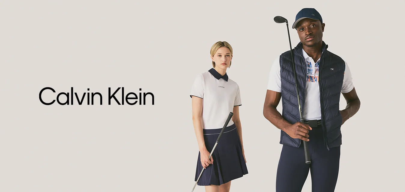 Due giovani adulti sono in piedi con mazze da golf indossando abbigliamento sportivo da golf su uno sfondo semplice.