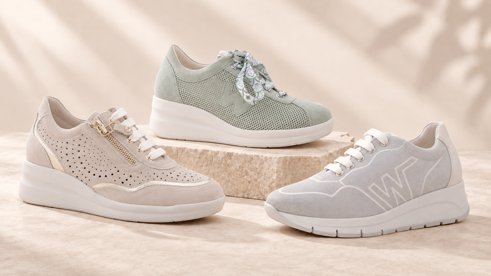 Three women's sneakers in beige mint and gray on stone display; perforated suede, zipper and floral scarf laces.