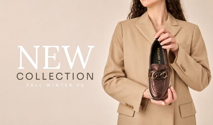 Cropped model in beige blazer holding a metallic brown loafer with chain buckle; text "New Collection Fall Winter 26" on left