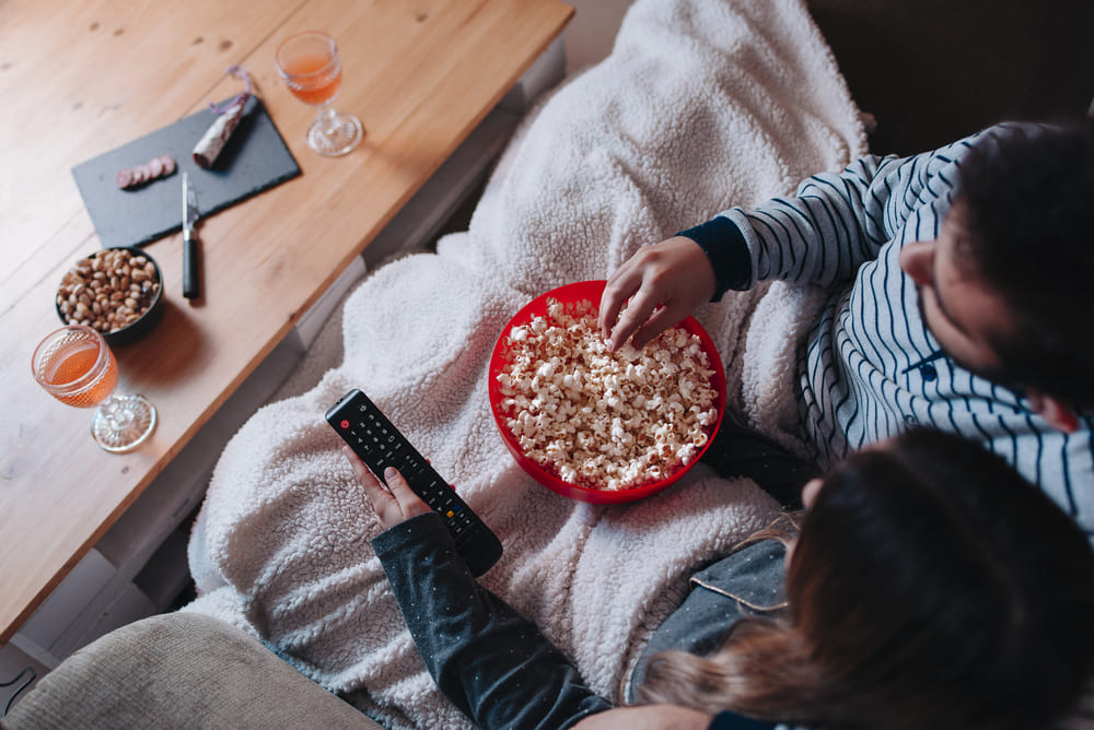 ragazza che mangia popcorn sul divano